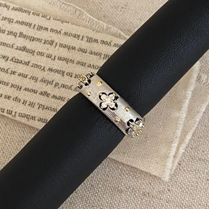 Macro view of vintage zircon open ring featuring brushed silver texture and gold accents