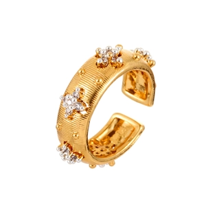 Macro detail of retro zircon open ring with gold brushed texture and silver floral accents