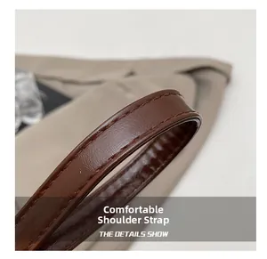 Detail showing the brown leather bag strap with reinforced double stitching craftsmanship
