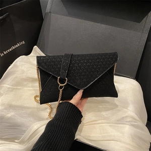 Elegant black woven envelope clutch with gold ring handle and chain strap for women
