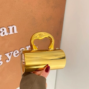 Luxury gold cylindrical acrylic handbag with sculptural handle and gold chain strap