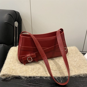 Borsa a spalla rossa in pelle con fiocco e fibbia argentata su tessuto morbido