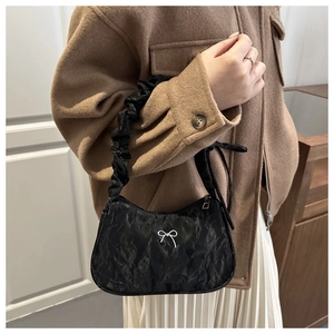 Détail du sac croissant plissé noir avec nœud argenté et bandoulière style nuage élégante