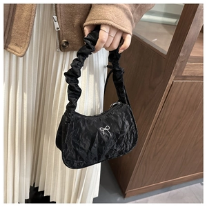 Détail du sac croissant plissé noir avec nœud argenté et anse froncée élégante