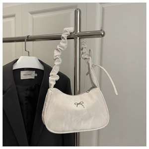 Détail du sac hobo blanc à texture marbrée avec nœud argenté et bandoulière froncée