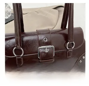 Detailed shot of dark brown glossy leather handbag with vintage silver buckle and rivets