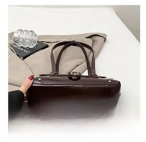 Detailed view of the wear-resistant wide base and silver studs of a brown vintage handbag