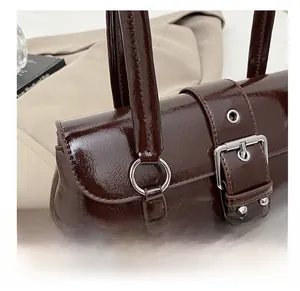 Close-up of premium silver rivets and buckle on dark brown glossy vintage biker bag