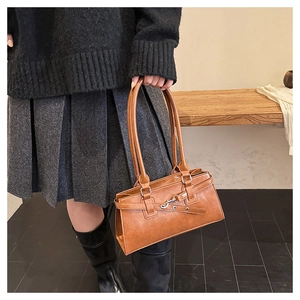Detailed shot of brown faux leather texture and silver buckle on a vintage underarm bag