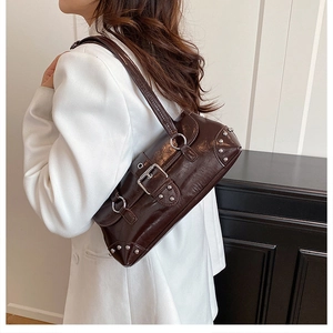 Detail of vintage dark brown faux leather shoulder bag with silver studs and buckle