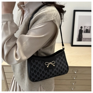 Detail der Schleife auf einer Retro-Schultertasche aus Jacquard-Stoff in Schwarz