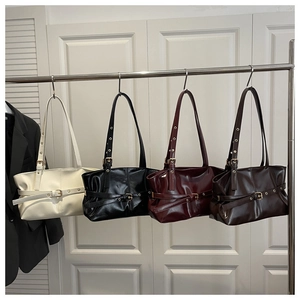 Detail view of four luxury oil wax leather shoulder bags in cream, black, burgundy and brown