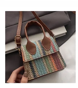 Close-up of colorful striped woven mini bag with brown leather handles and strap