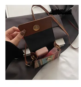 Detail of colorful woven mini crossbody bag interior showing the magnetic gold closure