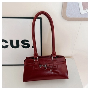 Detail shot of a dark red vintage faux leather shoulder bag with metallic buckle accent