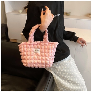 Détail du sac cabas rose matelassé avec étiquette Love Fashion porté à l'épaule