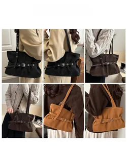 Detail view of suede tote bags with belt buckles in black, brown, and caramel colors