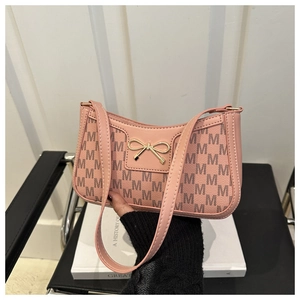 Detailaufnahme der rosa Unterarmtasche mit Monogramm-Muster und goldener Schleifenschnalle