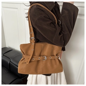 Detail of caramel brown faux leather underarm bag with silver buckles and stitch accents