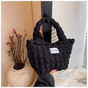 Gros plan sur le sac à main noir texturé à bulles avec étiquette LOVE FASHION