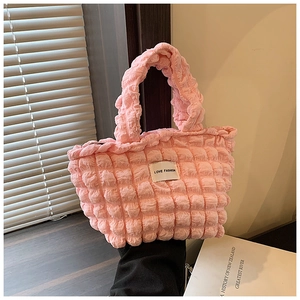 Détail du sac cabas rose à texture bulle avec étiquette Love Fashion sur bois