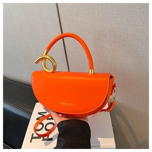 Fashionable orange saddle bag with gold knotted hardware and crossbody shoulder strap