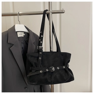 Detail of black matte leather shoulder bag with silver eyelets and buckle accents