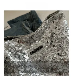Détail du sac seau à paillettes argentées avec une étiquette FASHION transparente