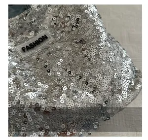 Détails macro d'un tissu à paillettes argentées et étiquette mode sur un sac à bandoulière