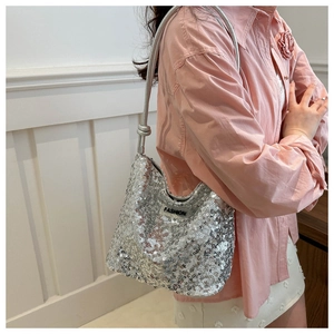 Détail du sac à bandoulière à paillettes argentées montrant la texture et le logo FASHION