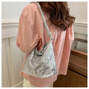Détail du sac à bandoulière à paillettes argentées avec patch FASHION sur modèle