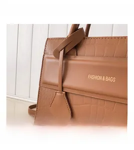 Gros plan d'un sac à main marron en cuir crocodile avec lettrage doré élégant