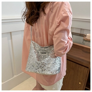 Sac à bandoulière à paillettes argentées avec étiquette FASHION porté par modèle