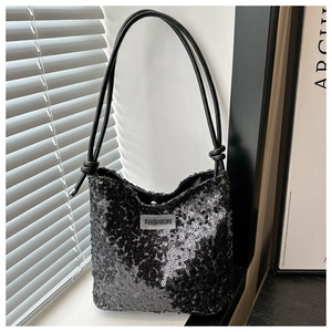 Détail du sac seau à paillettes avec texture brillante et bandoulière en cuir nouée