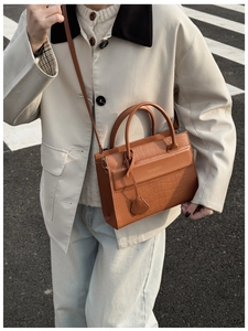 Sac à main marron avec motif pierre gaufré, détails dorés et bandoulière en vue extérieure