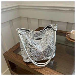 Détail du sac à bandoulière à paillettes argentées avec étiquette fashion et anses nouées
