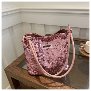 Détail du sac à bandoulière à paillettes roses avec logo FASHION et poignée nouée