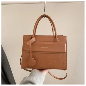 Détail du sac bandoulière marron gaufré crocodile avec anses et logo tendance