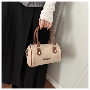 Détail d'un sac oreiller en daim beige vintage tenu par une personne en tenue