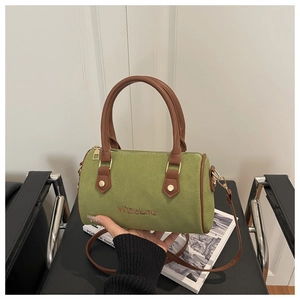 Détail du sac Boston en daim vert avec broderie M'DoLnu et poignée en cuir chic