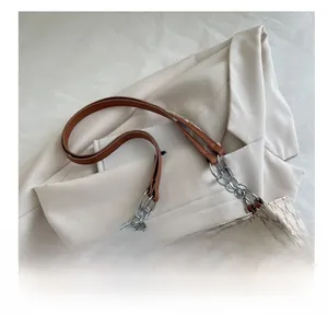 Detail of monogram patterned shoulder bag with brown leather strap and silver chain link