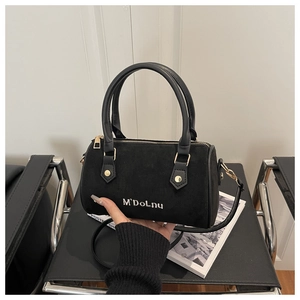 Détails du sac Boston en daim noir avec logo blanc et finitions métalliques dorées chic