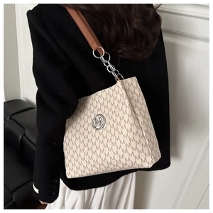 Detail of beige tote bag with M-letter jacquard pattern and metal logo on model