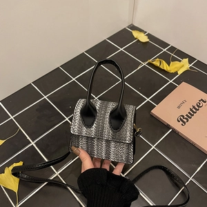Linen patchwork tweed crossbody bag with gold hardware on checkered tiles background