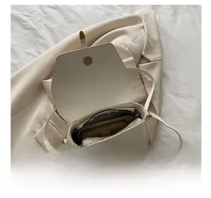 Detail showing the large interior capacity of this white leather crossbody square bag