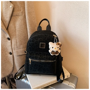 Detail eines Vintage-Rucksacks mit Leopardenmuster und Plüsch-Cartoon-Anhänger