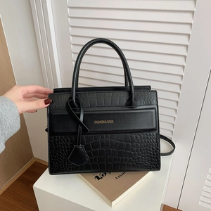 Sac à main rétro en cuir noir avec motif crocodile et doubles poignées sur support d'exposition
