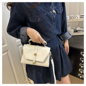 Detail of cream white PU leather crossbody bag with metal buckle and fixed handle