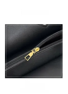 Detail of smooth gold zipper on premium black leather sequin shoulder bag