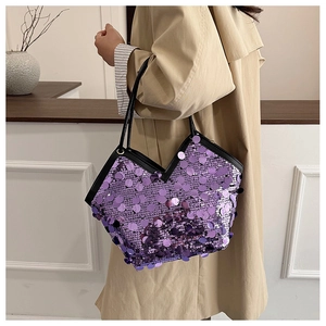 Detail of purple sequin tote bag with black leather trim and elegant V-shaped opening